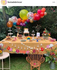 a table topped with lots of balloons and cake