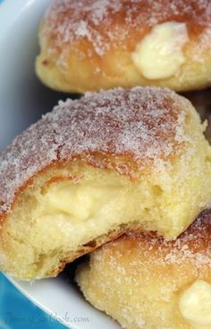 powdered sugar covered doughnuts in a white bowl