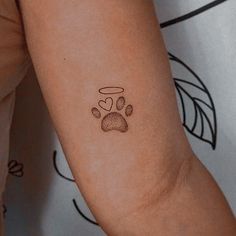 a small paw print on the arm of a woman's left arm, which is covered in brown ink