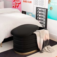 there is a black ottoman on the floor in this bedroom