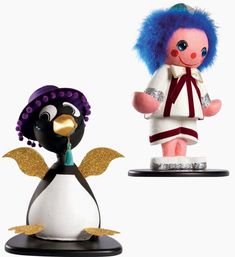 two small figurines, one with blue hair and the other wearing a white dress