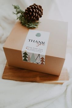 a brown box sitting on top of a wooden board next to a pinecone