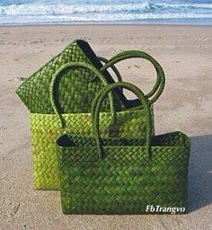 two green bags sitting on top of a sandy beach