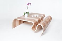 two wooden tables with flowers and rocks on the top one is shaped like a wave