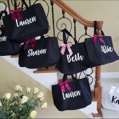 several personalized totes hanging from the banister