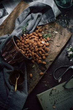 nuts are scattered on a cutting board next to a book