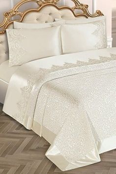 a bed with white sheets and pillows on top of it