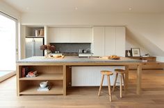 a kitchen with two stools next to an island