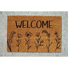 a welcome mat with flowers drawn on it