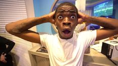 a man making a surprised face with his hands on his head while standing in front of a sink