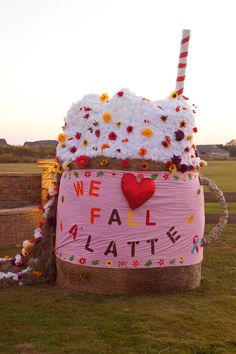 a giant ice cream sundae with flowers on it's side in the grass