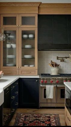 a kitchen with wooden cabinets and white counter tops, an area rug on the floor