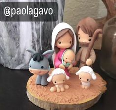 a nativity scene with figurines on top of a tree stump in front of a vase