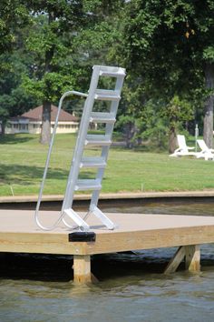 a white ladder sitting on top of a wooden dock