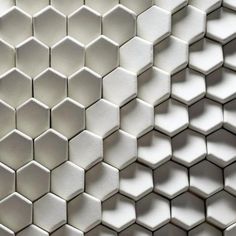 white hexagonal tiles are arranged in the shape of honeycombs on a wall