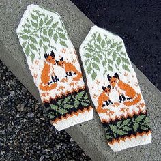 two knitted mittens sitting on top of a cement curb next to a street