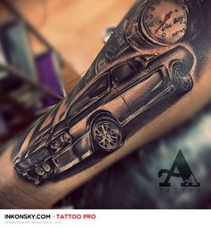 a man's arm with a black and grey tattoo design on it, featuring a car