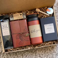 an open box with some items in it on the floor next to a cup and brush