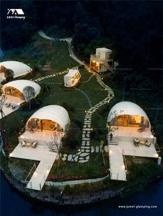 an aerial view of some tents in the middle of a field with lights on them