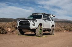 a white truck parked on top of a dirt road