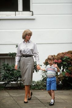 a woman walking next to a little boy