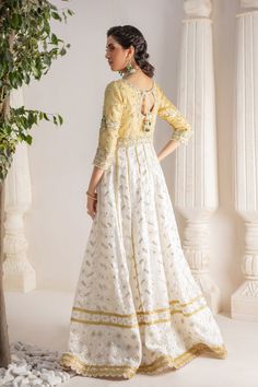 A contemporary Classic - Over a canvas of Pure chikankari chiffon, features a beautiful floral embroidered bodice further enhanced with dabka, sequins, pearls and kundan work. This classy peshwas is paired with gorgeous kamdani work dupatta, making this an absolute favorite for nikkah, engagement & other celebratory festivities Hand crafted tassels & straight pant completes the look of this outfit. Peshwas Fabric: Pure Chiffon Peshwas Length: 60” (customisable, mention in order notes) Sleeve length: 16” Pant Fabric: Khaadi Silk Dupatta Fabric: Georgette Chiffon Color: Ivory & Gold This outfit is fully lined, neck key-hole can be lined on request, mention in order notes. Please refer Size Guide Before selecting size For Customised measurements please select Custom size for an additional 20$ White Chinon Designer Dresses, Fitted Raw Silk Dress With Chikankari Embroidery, White Anarkali Dress In Chinon, Designer White Gown With Dabka Work, Elegant Cream Dresses With Mirror Work, Designer Cotton Silk Lehenga With Intricate Embroidery, Designer Cotton Silk Gown With Zari Work, Silk Choli With Chikankari Embroidery For Reception, Cotton Silk Dress With Dabka Work For Wedding