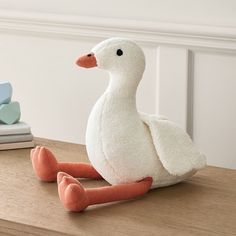 a stuffed duck sitting on top of a wooden table