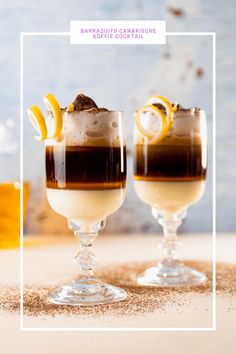 two glasses filled with drinks sitting on top of a table next to eachother