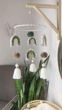 a plant in a basket next to a wall hanging with beads and tassels