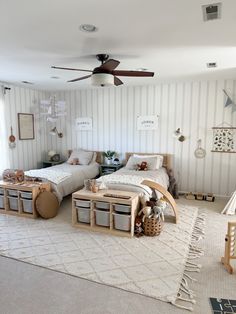 two twin beds in a bedroom with striped walls and rugs on the floor next to each other