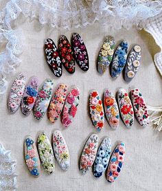 nine pairs of flowered hair clips on a white cloth with laces around them