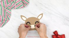 someone is making a reindeer mask out of paper