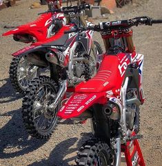 two red dirt bikes parked next to each other