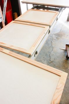 three pieces of wood sitting on top of each other in front of a workbench