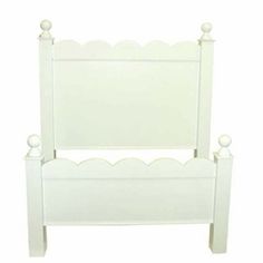 a white bed frame with scalloped headboard and foot board on an isolated white background