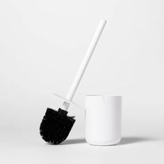 a white cup with a black brush in it