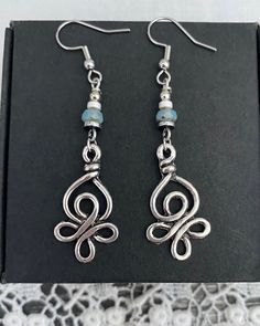 Silver Celtic inspired knot drop earrings. This earring is a finer style earring and lightweight to wear. The Celtic inspired knot is a silver plated charm. To join the charm to the earring hooks  I have used non magnetic hematite beads in silver and white, with a Czech pressed glass bead, in mauve or green. The earring hooks are stainless steel. The total drop of the earring, measured from the top of the earring hook is 60mm or 2 ½ inches. ♥︎ STAINLESS STEEL EARRING HOOKS  Stainless earring hoo Unique Silver Beaded Drop Earrings, Distinctive Silver Wire Wrapped Beaded Earrings, Unique Silver Wire Wrapped Beaded Earrings, Bohemian Silver-plated Drop Earrings, Bohemian Silver Plated Drop Earrings, Silver Bohemian Beaded Earrings For Gift, Bohemian Silver Plated Wire Earrings For Jewelry Making, Bohemian Sterling Silver Beaded Earrings Wire Wrapped, Bohemian Sterling Silver Wire Wrapped Beaded Earrings