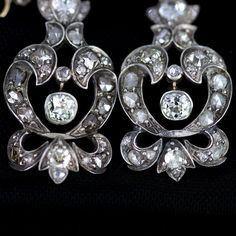 "Georgian silver topped 14k gold drop earrings with over 5 carats of diamonds feature a combination of old mine cut and rose cuts. The stunning earrings have been preserved for nearly 200 years. One has been repaired at some point in its history of ownership. The bottom flourish was reattached and the top of the pendulous was reinforced and reattached. See detailed imagery of repairs. These have not been cleaned by us in case of foil backings on non open backed stone mountings, which were preval Formal Rose Cut Diamond Chandelier Earrings, Formal Chandelier Earrings With Rose Cut Diamonds, Vintage Rose Cut Diamond Earrings, Elegant Chandelier Earrings With Rose Cut Diamonds, Classic Rose Cut Diamond Earrings For Evening, Victorian Diamond White Diamond Earrings For Formal Occasions, Victorian Diamond White Earrings For Formal Events, Antique Diamond Wedding Earrings, Vintage Rose Cut Diamond Earrings For Formal Occasions