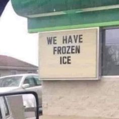 we have frozen ice sign on the side of a building in front of a car