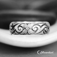 a close up of a wedding ring on a white plate with a black and white background