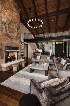 a living room filled with lots of furniture and a fire place in the middle of it