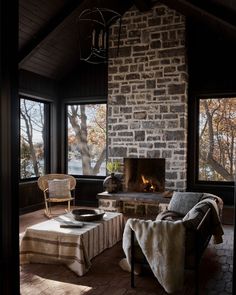 a living room filled with furniture and a fire place in front of a brick wall