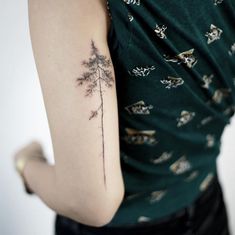 a woman's arm with a tattoo on it that has a plant growing out of it