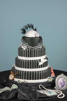 a three tiered cake with black and white stripes on it's sides, decorated with decorations