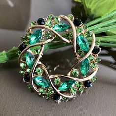 Green crystal rhinestone wreath brooch pin Height: 1.8 inch ( 4.6cm ) Width: 1.8 inch ( 4.6 cm ) Condition: Vintage condition Found in: The Netherlands Material: Green color crystal, rhinestone, metal Please know that the items for sale in my shop are vintage pre-owned items, not in their original condition and may show signs of wear due to age and use. There may be minor flaws such as light scuffs, tarnish, color fade, scratches, etc. View the photos to evaluate the condition Your item will be Green Round Brooch Jewelry, Green Round Brooch, Green Round Brooches For Wedding, Green Round Wedding Brooches, Green Crystal Brooch Jewelry, Rhinestone Wreath, Green Brooch, Vintage Rhinestone Brooch, Floral Jewelry