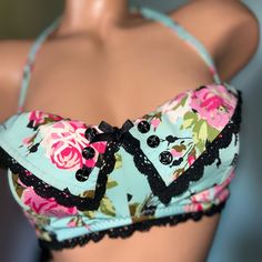 a female mannequin wearing a blue and pink floral bra with black lace trim