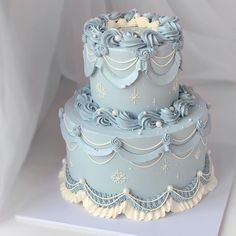 a three tiered blue cake with frosting decorations