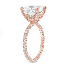 a rose gold engagement ring with an oval cut diamond surrounded by round brilliant pave diamonds