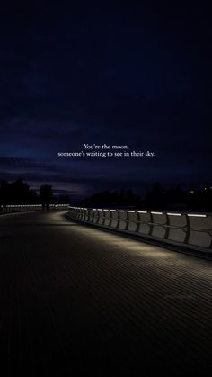 an empty walkway at night with the quote you're the moon