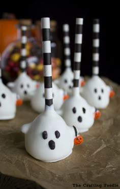 there are some white ghost candies with black and white striped sticks sticking out of them